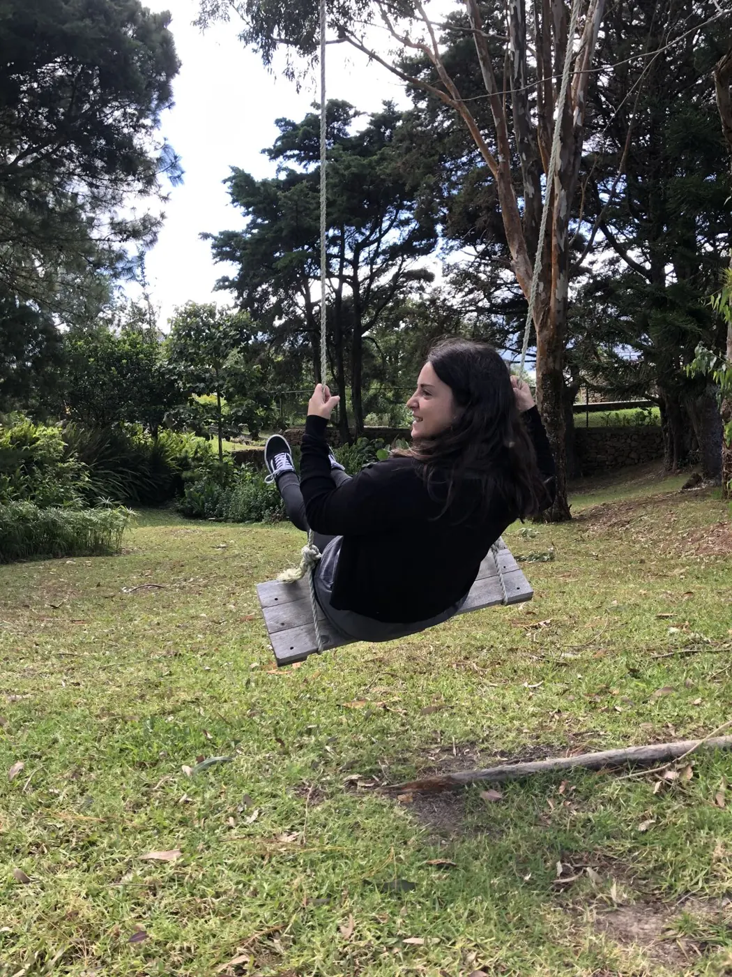 Persona en un columpio entre los árboles del jardín